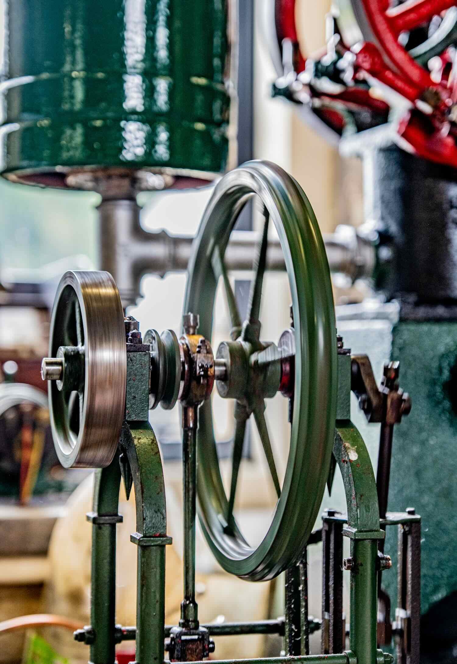 A machine featuring green-colored wheels displayed in the workshop